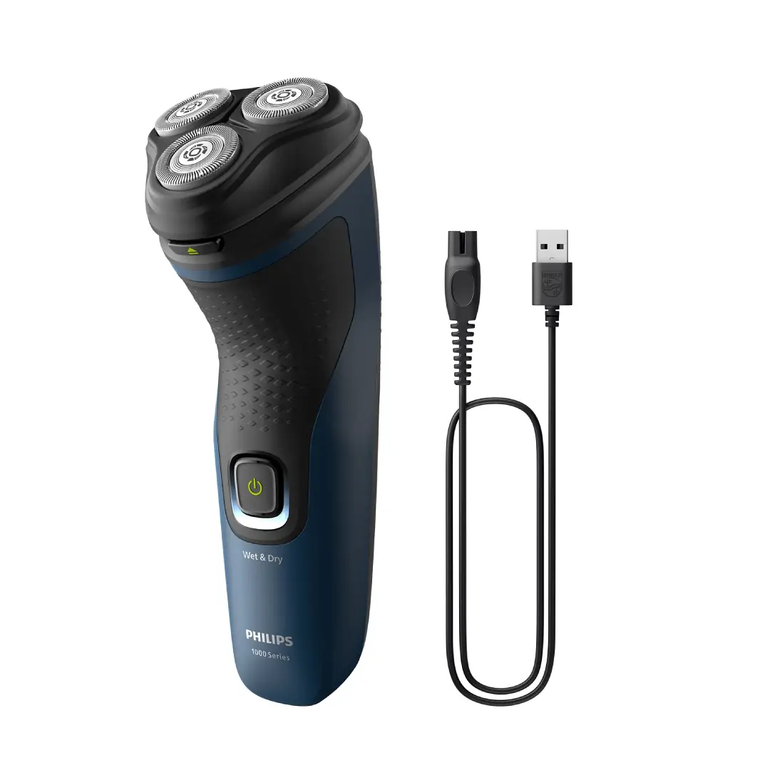 Vista de la afeitadora Philips S-1151/00 junto a su cable de carga USB, mostrando la facilidad para cargar el dispositivo en cualquier lugar - Electrocash