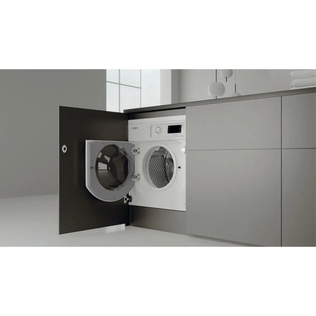 Fotografía de la lavadora integrable Whirlpool BI WMWG-81485E EU instalada en una cocina, destacando su diseño empotrado, moderno y funcional, perfecta para espacios elegantes, disponible en Electrocash.